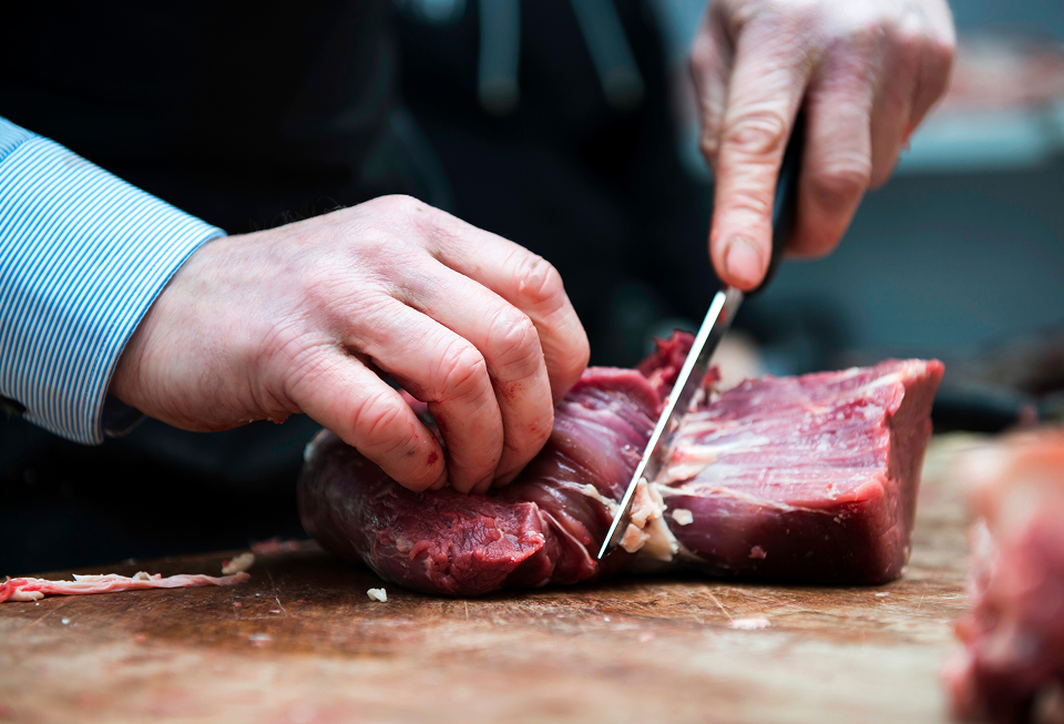 Découpe d'un steak halal de boeuf par un cuisinier